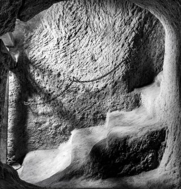 Gri tonda merdiveni olan eski bir mağaranın içi.