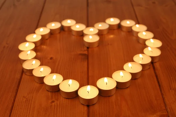 木製のテーブルや床に心を作る小さなキャンドル ロマンチックな夜 — ストック写真