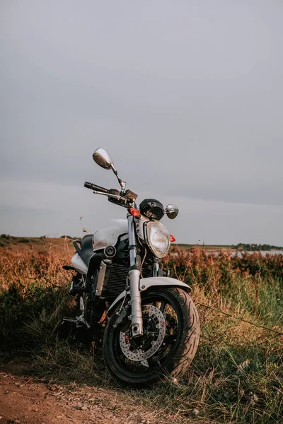 Vintage Motocykl Zaparkowany Pobliżu Pięknego Jeziora Podczas Zachodu Słońca Niebem — Zdjęcie stockowe