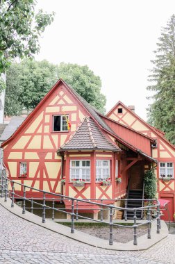 Meersburg 'da arka planda ağaçlar olan yarı ahşap bir evin dış tasarımının dikey görüntüsü.