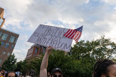 Protestocular, Anayasa Mahkemesi 'nin ABD' nin NYC eyaletindeki Washington Square Park 'ta Roe V. Wade' i devirmesinin ardından vücut özgürlüğüyle ilgili mukavva tabelalar tutuyorlar.