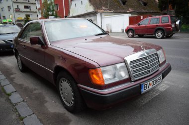 Romanya 'nın Brasov kentinde bir caddeye park edilmiş klasik koyu kırmızı bir arabanın güzel bir görüntüsü