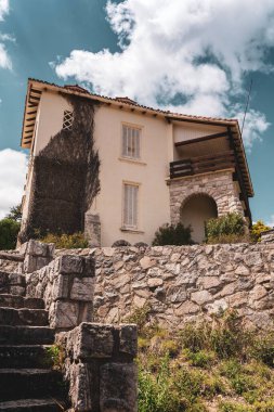 Bulutlu bir arkaplanı olan güzel beyaz bir evin yakın çekimi.