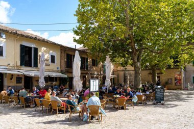 İspanya 'nın Balear Adaları' ndaki Mallorca (Mayorka) şehrinde güneşli bir günün tadını çıkaran insanların olduğu bir restoran.