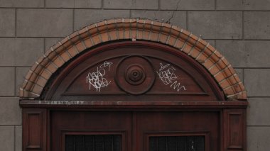 Beyaz grafiti etiketli kahverengi kapının yakın çekimi.