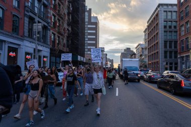Protestocular, Anayasa Mahkemesi 'nin ABD' nin NYC eyaletindeki Washington Square Park 'ta Roe V. Wade' i devirmesinin ardından vücut özgürlüğüyle ilgili mukavva tabelalar tutuyorlar.