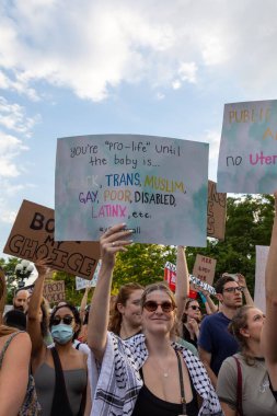 Protestocular, Anayasa Mahkemesi 'nin ABD' nin NYC eyaletindeki Washington Square Park 'ta Roe V. Wade' i devirmesinin ardından vücut özgürlüğüyle ilgili mukavva tabelalar tutuyorlar.