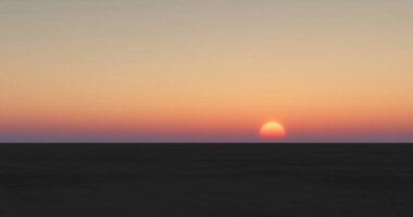 Kızıl günbatımında geniş bir çölün siluetinin bir çizimi.