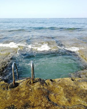 Malta 'da bir plajda küçük bir taş havuzun dikey çekimi.