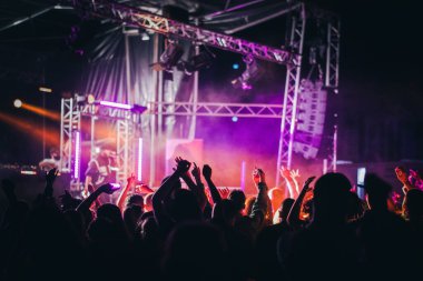 Dans eden kalabalık ve disko ışıklarının olduğu bir müzik etkinliği.