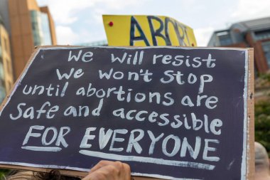 Protestocular, Anayasa Mahkemesi 'nin ABD' nin NYC eyaletindeki Washington Square Park 'ta Roe V. Wade' i devirmesinin ardından vücut özgürlüğüyle ilgili mukavva tabelalar tutuyorlar.