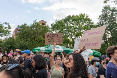 Protestocular, Anayasa Mahkemesi 'nin ABD' nin NYC eyaletindeki Washington Square Park 'ta Roe V. Wade' i devirmesinin ardından vücut özgürlüğüyle ilgili mukavva tabelalar tutuyorlar.