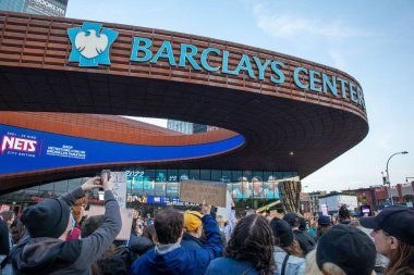 Brooklyn, New York, ABD 'deki Barclays Center' da karton tabela tutan genç bir kadın.