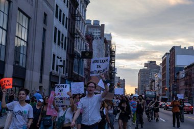 Protestocular, Anayasa Mahkemesi 'nin ABD' nin NYC eyaletindeki Washington Square Park 'ta Roe V. Wade' i devirmesinin ardından vücut özgürlüğüyle ilgili mukavva tabelalar tutuyorlar.