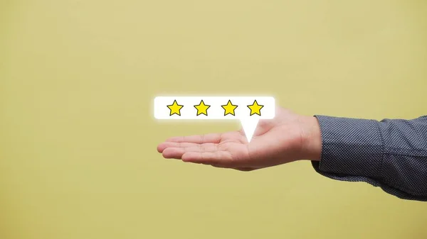 一个白种人伸出他的手掌 手上拿着一张二维的图片 上面有一颗星的评级在他手上浮动 — 图库照片