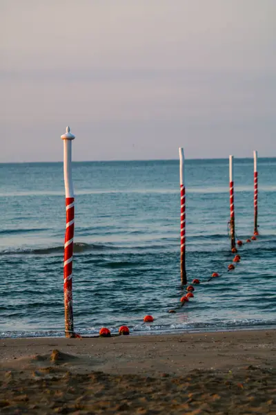 Eine Vertikale Aufnahme Eines Wunderschönen Blauen Meeres Mit Roten Metallstangen — Stockfoto