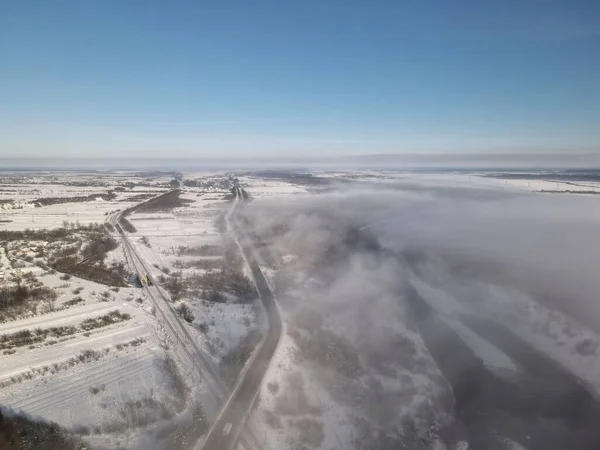 霧の多い冬の天気の間の雪道とフィールドの高角度ビュー ウクライナ — ストック写真