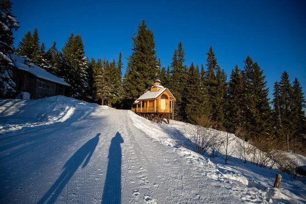 雪の山の中に木造の家がある幻想的な冬の風景 — ストック写真