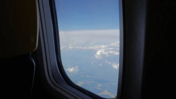 飛行機の窓から青い空とふわふわの雲の景色 — ストック写真