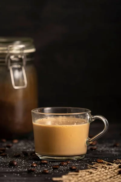 Een Koffie Met Melk Een Glazen Kopje Met Koffiebonen Tafel — Stockfoto