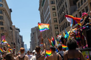 LGBT bayraklı bir kalabalık bir geçit töreninde yürüyor.