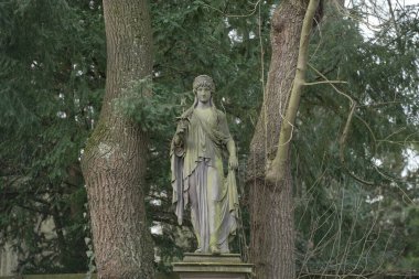 Osnabruck 'taki mezarlıkta bir kadın taş heykeli.