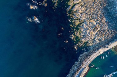 Liman girişinin hava manzarası dalgalı, kayalık sahil