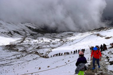 Bir grup insan, Cusco yakınlarındaki Peru And Dağları 'ndaki Vinicunca Gökkuşağı Dağı' na yürüyüş yapıyor.