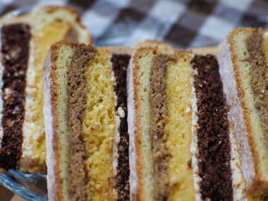 Beyaz, çikolata hamurlu ve farklı kremalı bir pasta.