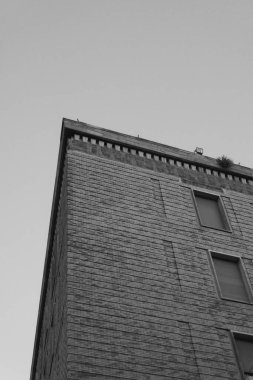 Düşük açılı gri tonlu, taş tuğladan dış duvarları olan modern bir bina.