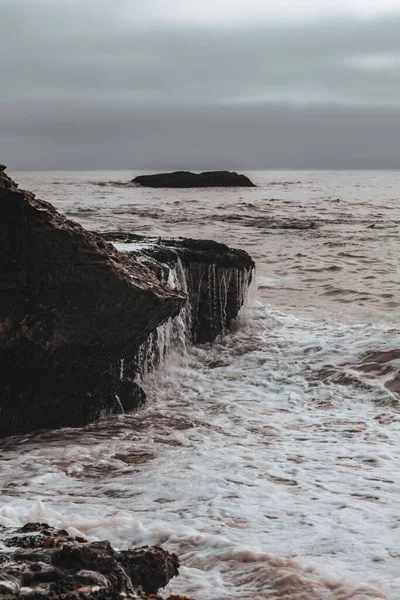 Een Verticaal Schot Van Oceaangolven Die Rotsen Raken Het Strand — Stockfoto