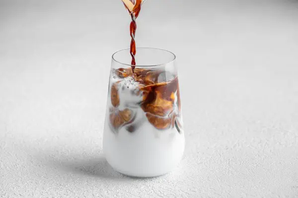 Beyaz Arka Planda Buzlu Latte Olan Cam Bardağa Yakın Plan — Stok fotoğraf