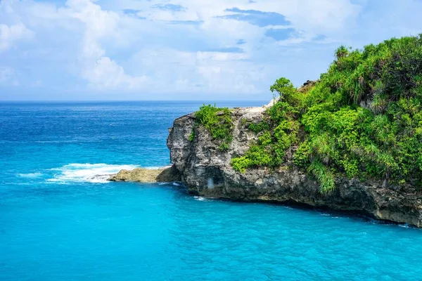 Ein Felsiger Hügel Mit Graspflanzen Blauen Ruhigen Wasser Unter Blauem — Stockfoto