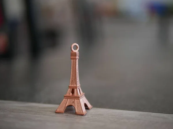 Close Uma Pequena Torre Eiffel Chaveiro Rosto Fundo Embaçado — Fotografia de Stock