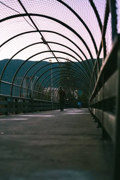 Вертикальный Снимок Длинного Арочного Туннеля Металлической Проволокой Небом Заката — стоковое фото
