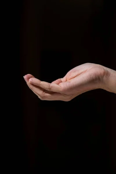 Eine Vertikale Aufnahme Einer Hand Vor Schwarzem Hintergrund Mit Kopierraum — Stockfoto