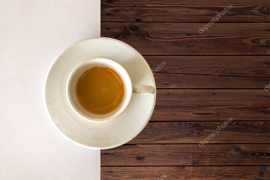 A top view of a white cup in a wooden table