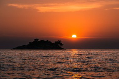 Hırvatistan 'ın huzurlu sonsuz denizi üzerinde parlak turuncu gün batımı