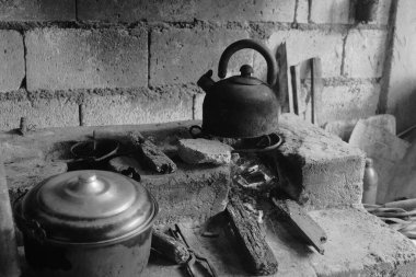 Terk edilmiş bir binada eski bir çaydanlığın siyah beyaz görüntüsü.