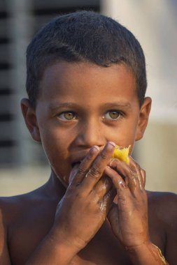 Zavallı Kübalı bir kız mango yiyor.