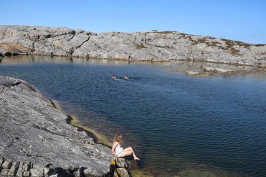 Norveç 'in batısındaki Oygarden' da küçük bir gölde yıkanan insanların manzarası..