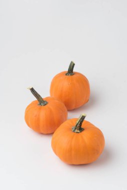 Beyaz arka planda izole edilmiş bir stüdyoda üç balkabağı resmi.