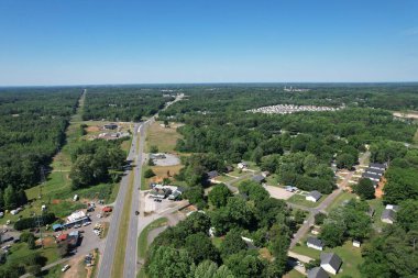 Ormanlarla çevrili bir kasabanın havadan görünüşü.