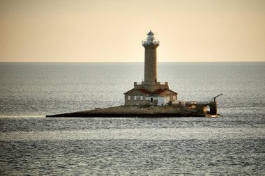 Gün batımında denizin ortasındaki deniz feneri manzarası
