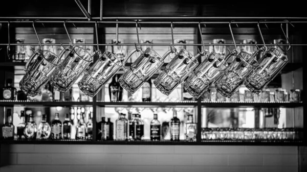 Een Zwart Wit Shot Van Glazen Bierbekers Opknoping Een Bar — Stockfoto
