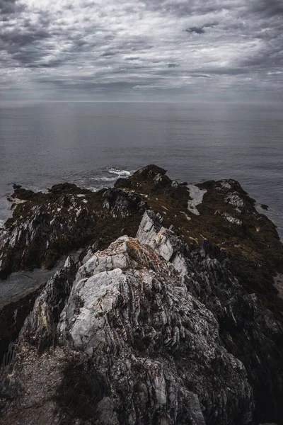 美丽的岩石海岸被苔藓覆盖 夜晚的云彩笼罩着平静的大海 — 图库照片