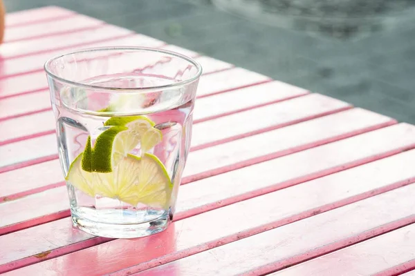 Glas Wasser Mit Zitronenscheiben Auf Dem Tisch Rosa — Stockfoto