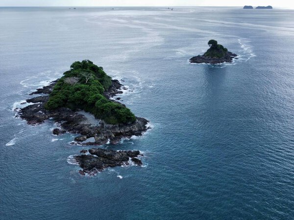 Вид с воздуха на небольшой остров с пышными зелеными деревьями и растительностью, окруженный огромным океаном