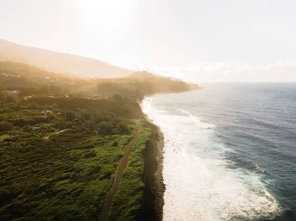 日の出に緑の崖に衝突する波の空中の眺め — ストック写真