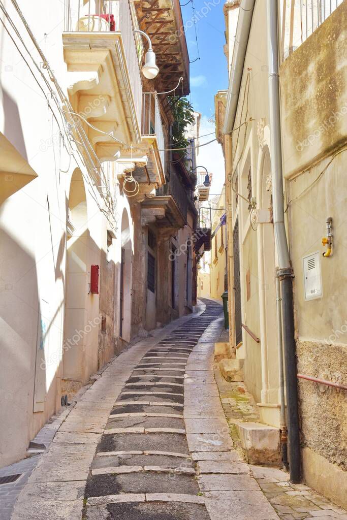 A vertical shot of a narrow street of Modica with beautiful architecture, Sicilian city in Italy